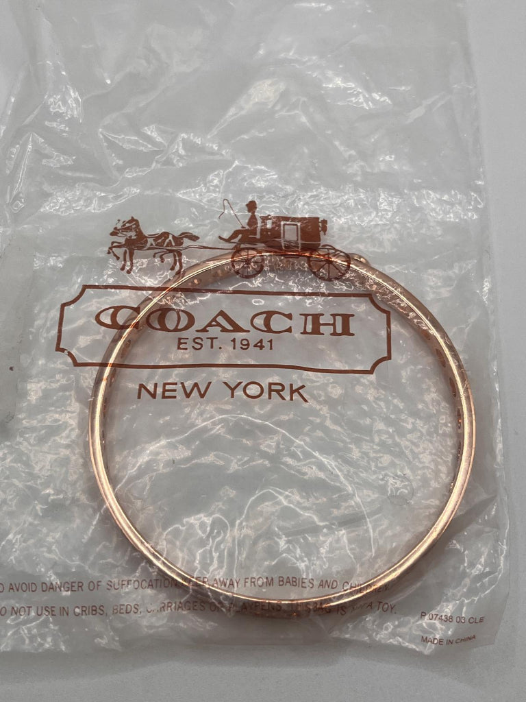 Coach bracelet in packaging with brand logo on a gray background