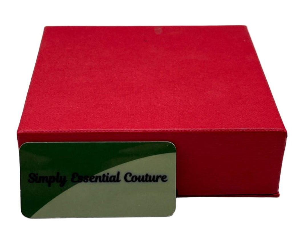 Red H.Samuel box with a green card displaying 'Simply Essential Couture' on a white background