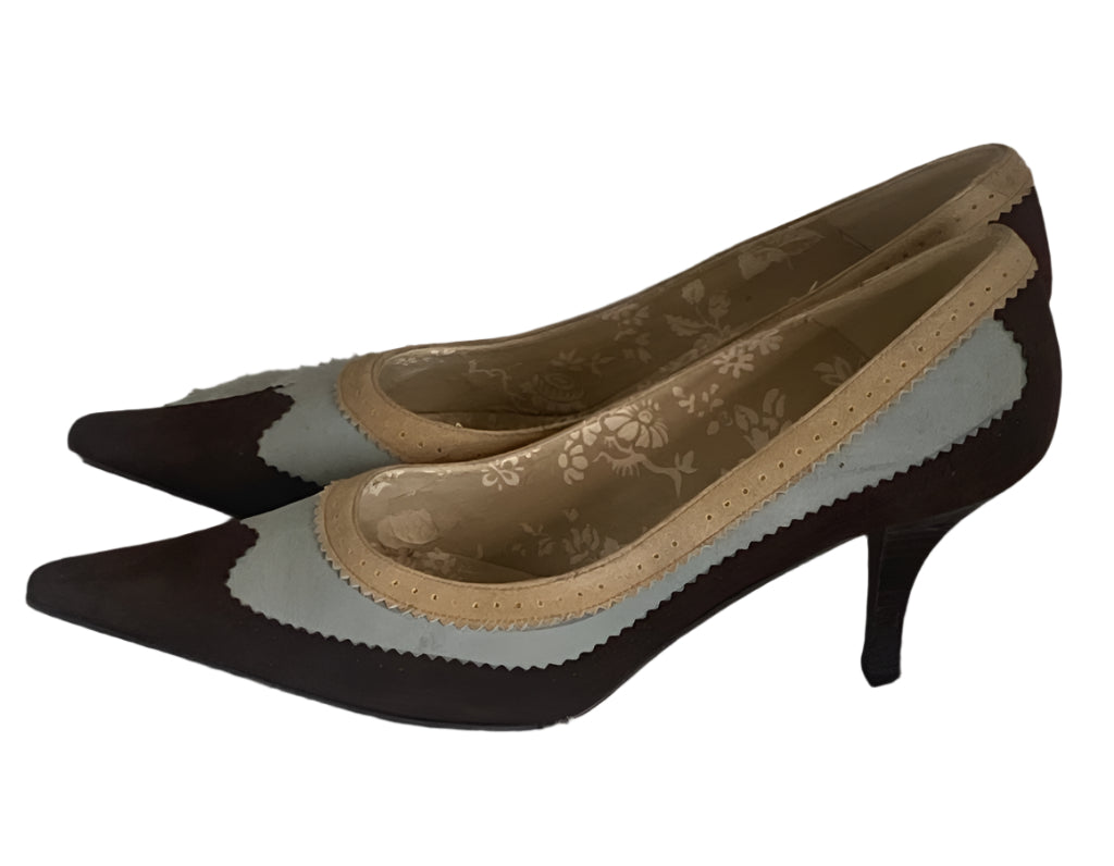Pair of high-heeled shoes with a floral pattern on a textured surface