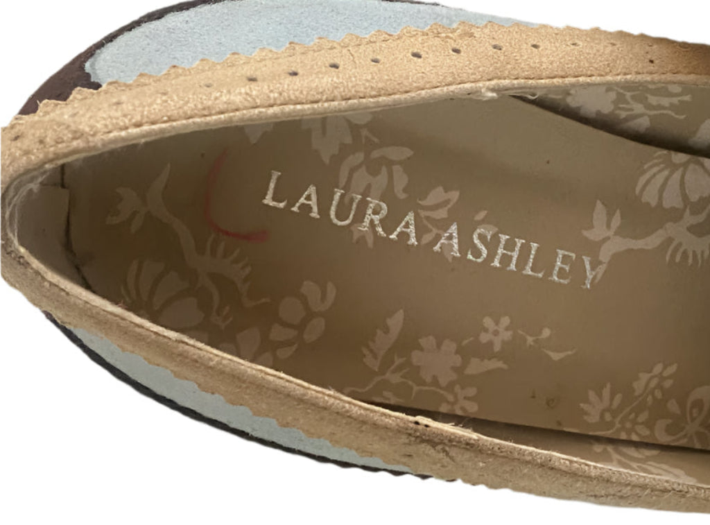 Close-up of a shoe sole with 'Laura Ashley' branding on a white background