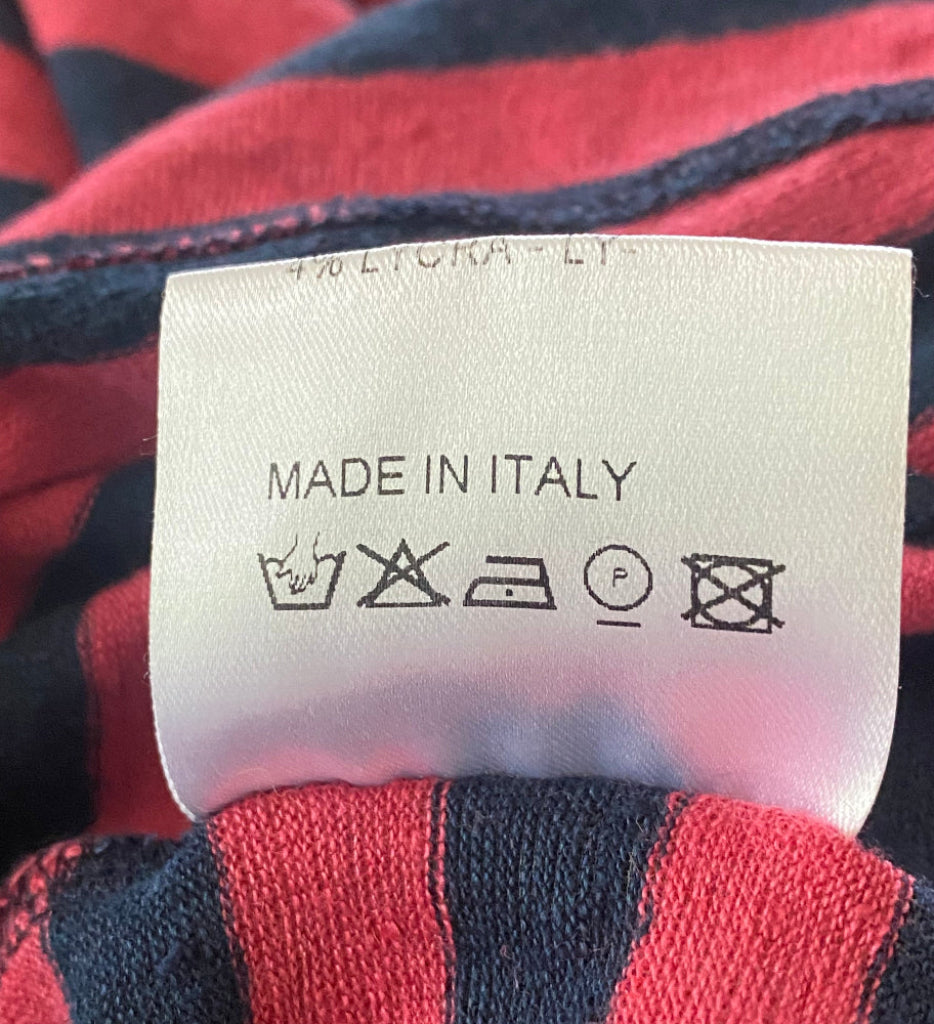 Clothing label with 'Made in Italy' text on a red and blue striped fabric background