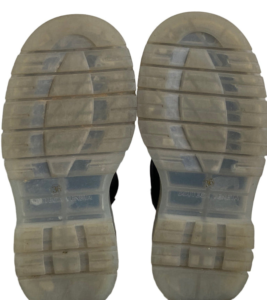 Close-up of boot soles with visible tread pattern on a white background