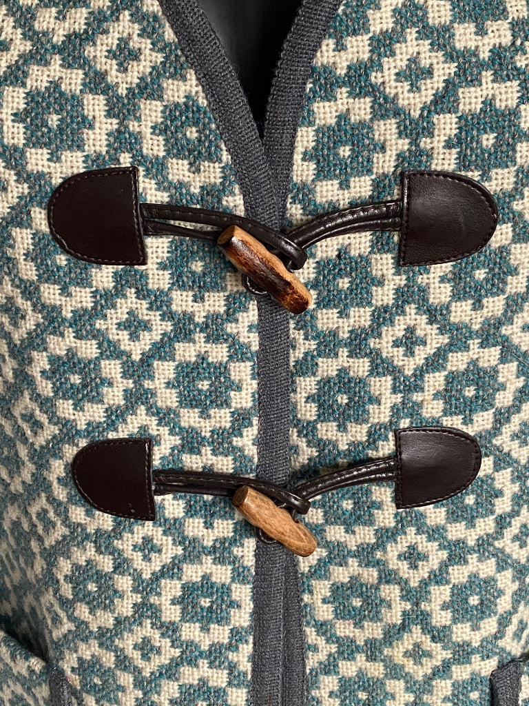 TREFRIW Close-up of a patterned fabric with black buttons and wooden toggles.