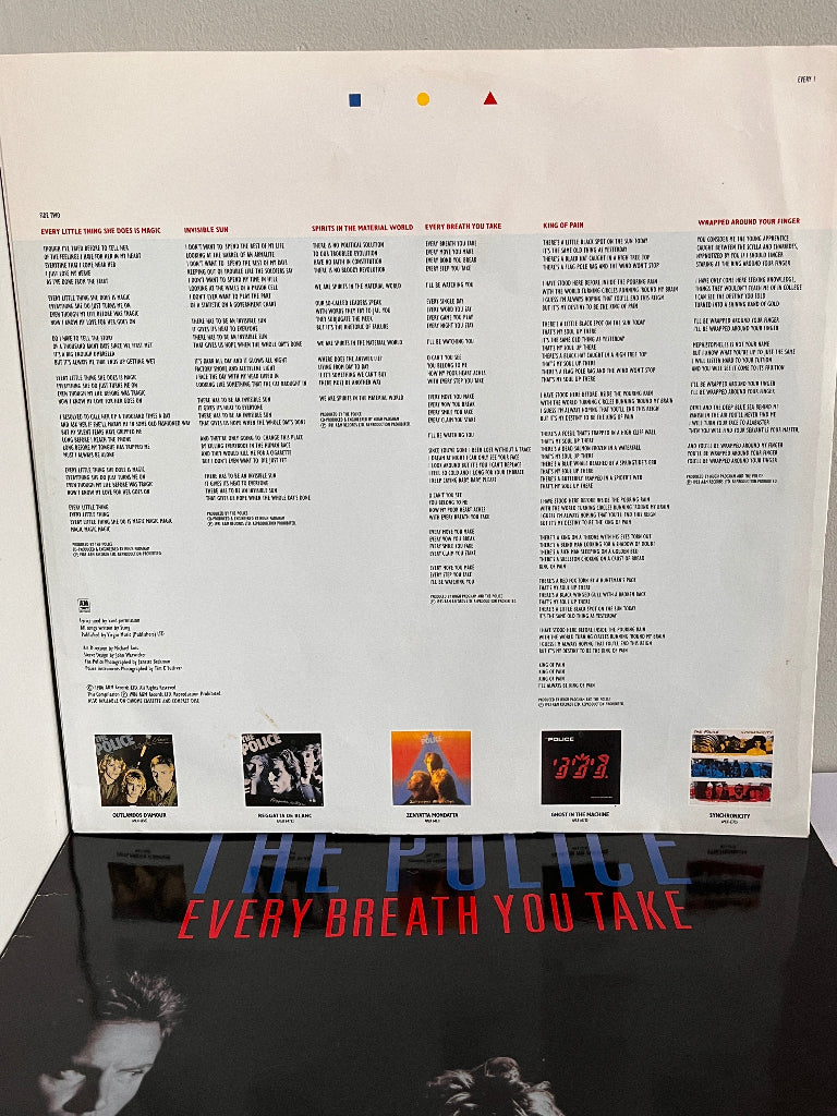 Back cover of vinyl record with tracklist and album cover images, featuring 'The Police' and 'Every Breath You Take'.