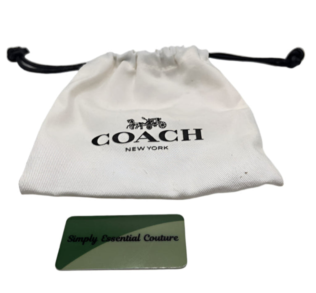 White drawstring bag with 'Coach New York' logo and a green card with text on a white background