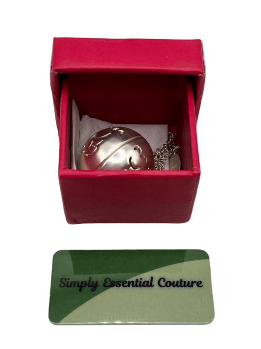 Silver bell charm in a red box with 'Simply Essential Couture' card below