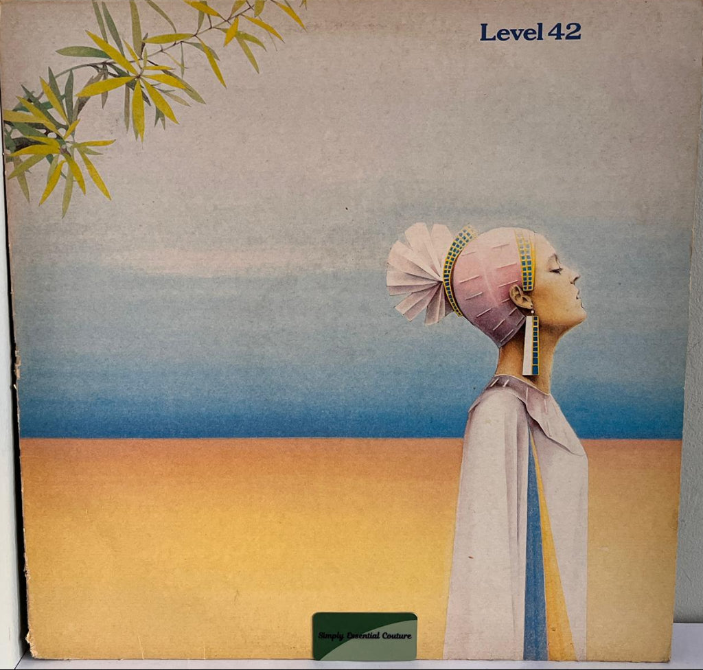 Level 42 Album cover with a stylized illustration of a person with a pink headscarf and a landscape.