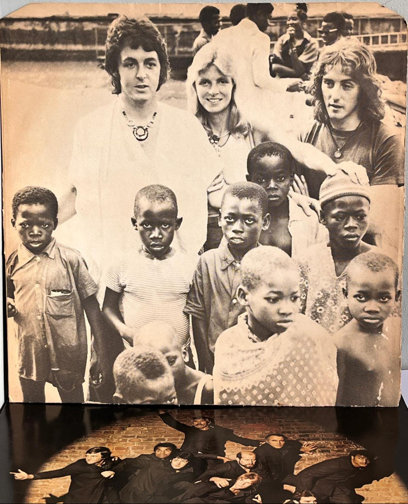 Wings - Band On The Run. Black and white photo of a group of people, including children, with a wooden frame.