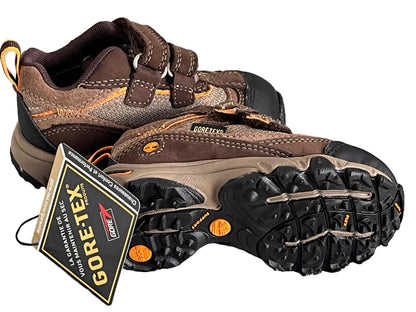 Brown hiking boots with GORE-TEX label on a striped fabric background