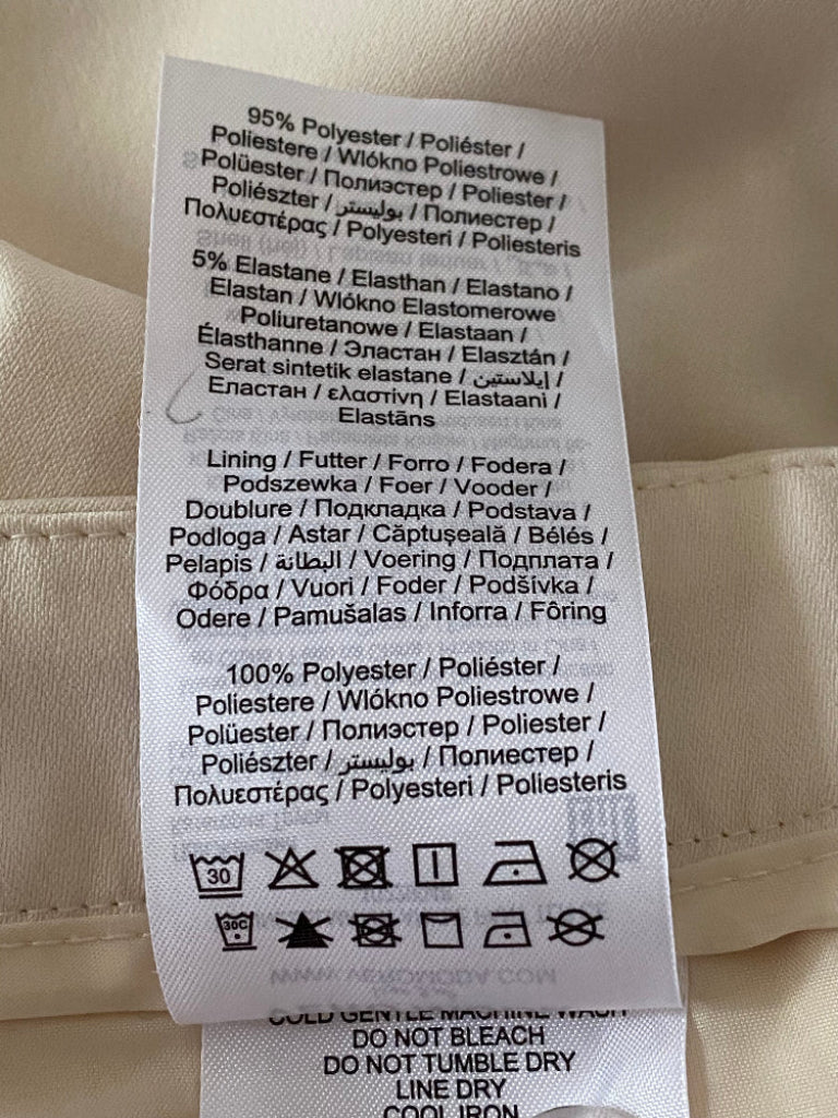 Clothing label with fabric composition and care instructions on a beige background