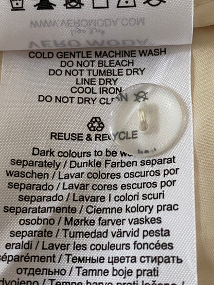 Clothing label with washing instructions and recycling symbol on a beige fabric background