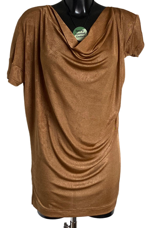 Gold draped dress on a mannequin with a white background