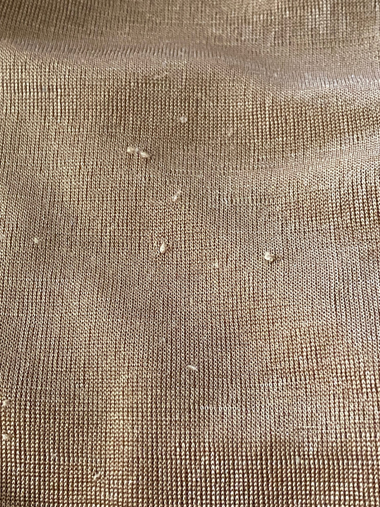 Close-up of textured gold fabric with visible fibres