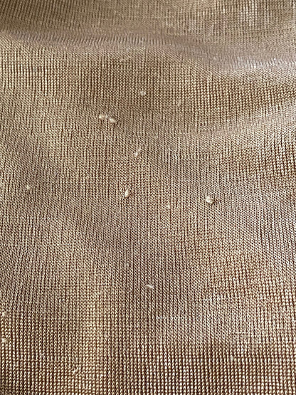 Close-up of textured gold fabric with visible fibres