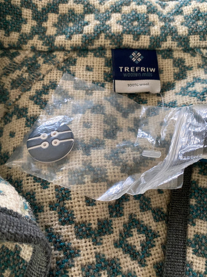Button with packaging on a patterned fabric background, featuring the TreFriw brand.