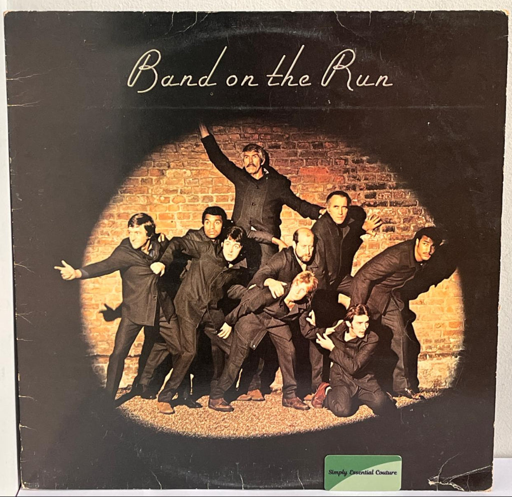 Vinyl record cover for 'Band on the Run' featuring a group of people against a brick wall.
