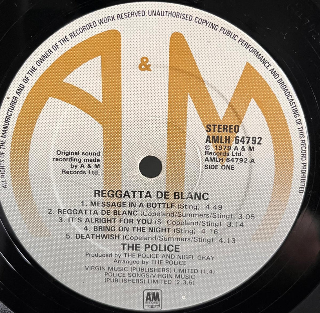 Vinyl record label with 'A&M' logo and track listing for 'Reggatta De Blanc' Side 1 by The Police.